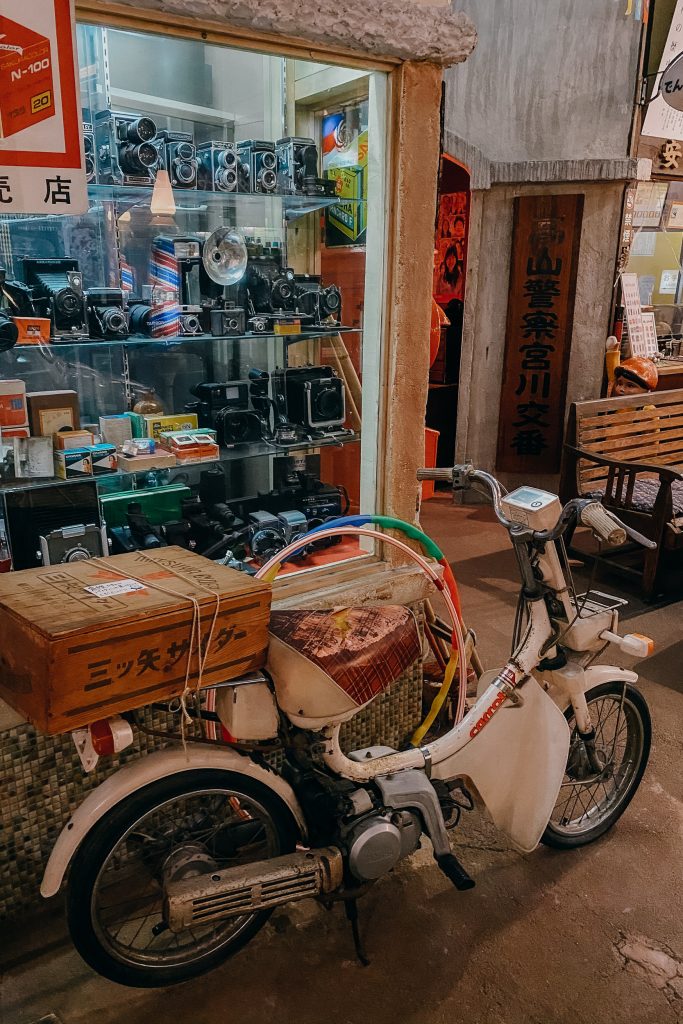 an old moped and display of photography store front at the showa museum in takayama