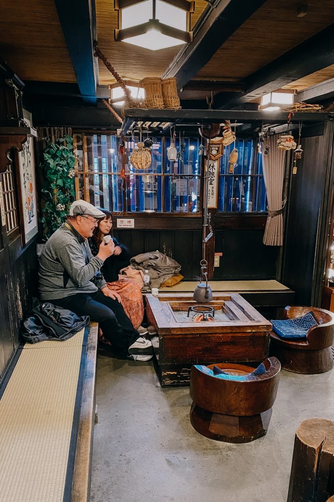 a couple sit and enjoy a sake tasting, one of the best things to do in takayama japan