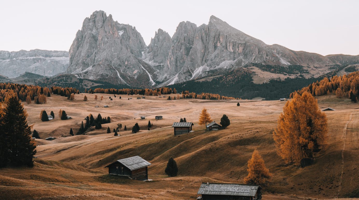 mountain huts on the alpe di siusi with the sassolungo mountain range in the background