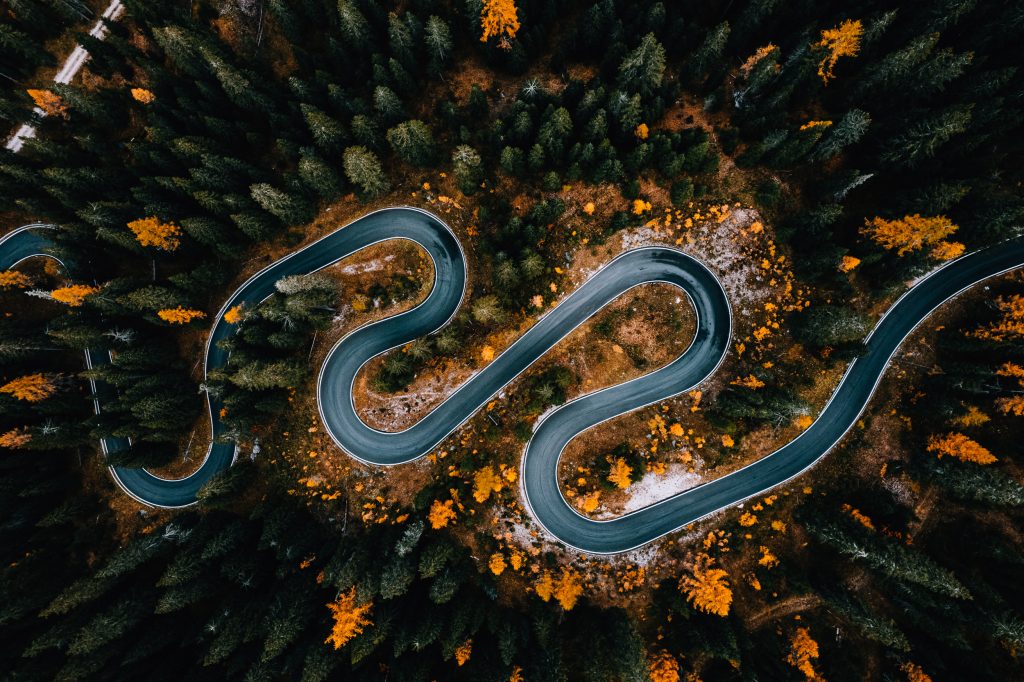 A road snakes through the trees in the Dolomites