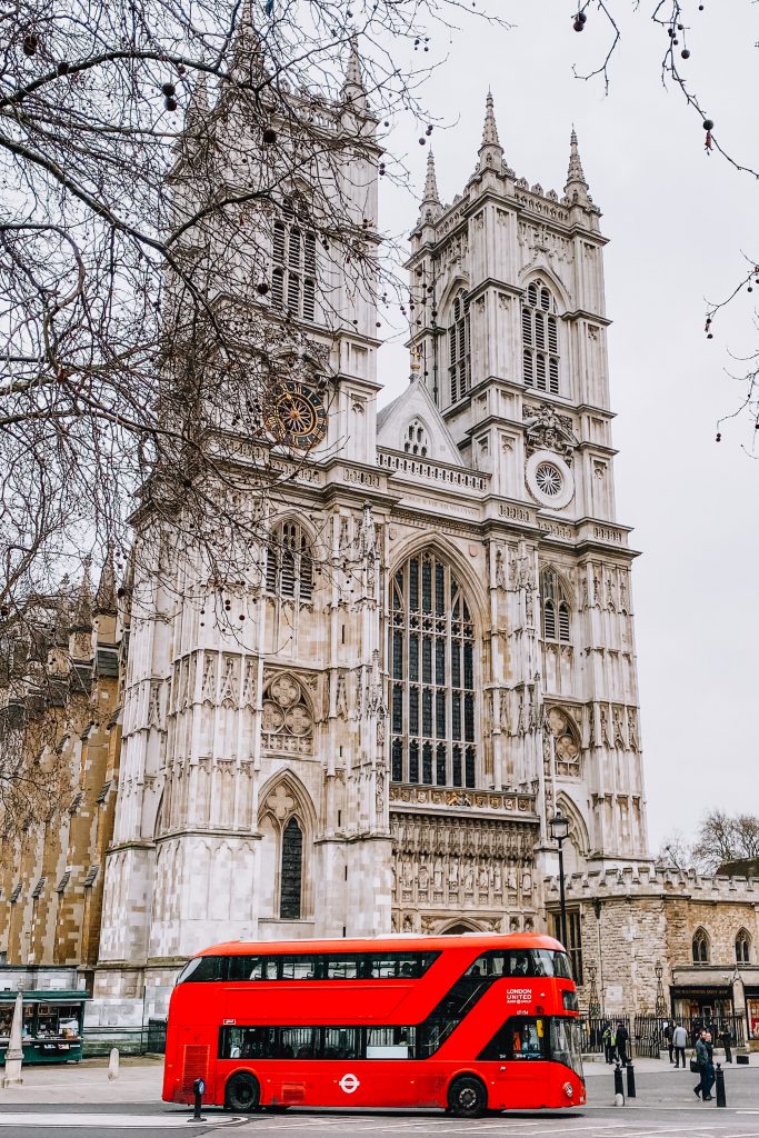 A red double decker London bus goes past the front of Westminster Cathedral during your 4 days in London itinerary