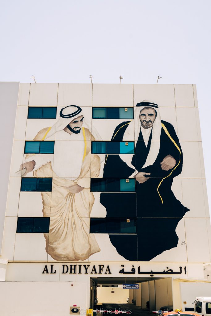 Street art of 2 men dressed in traditional Emirati robes