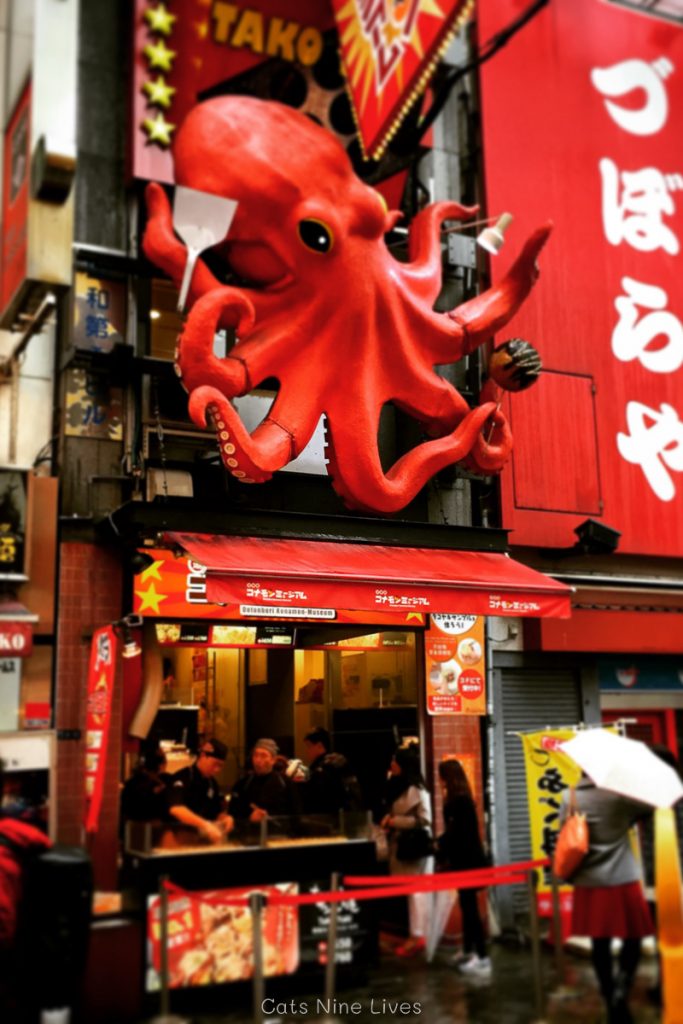 A massive red octopus hangs over a takoyaki stall in Osaka Japan